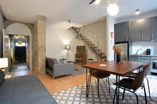 a kitchen and living room with a wooden table and chairs at Oporto City View - Santo Ildefonso in Porto