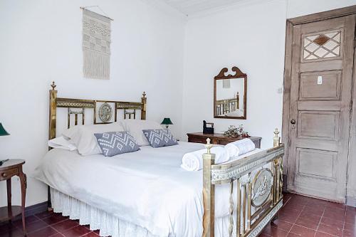 1 dormitorio con cama blanca y puerta de madera en Casona El Resguardo - Solo Adultos en Río Blanco
