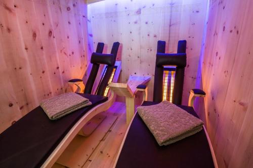 a room with three chairs in a room with purple lights at AusZeit in Oberammergau