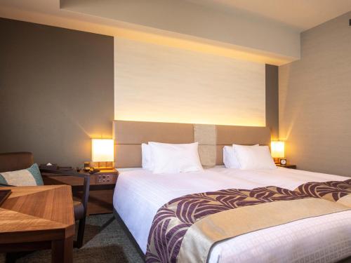 a hotel room with two beds and a table and two lamps at Tokyu Stay Kyoto Sakaiza Shijo Kawaramachi in Kyoto