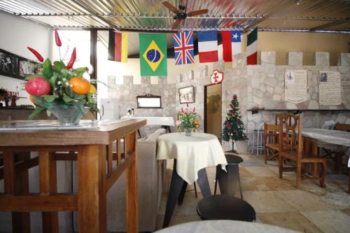 a restaurant with a table and flags on the wall at Pousada Lampião e Maria Bonita in Natal