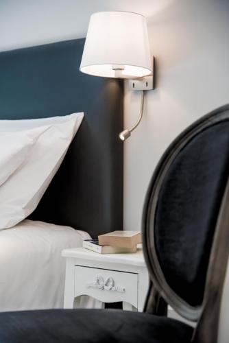 a bedroom with a bed and a lamp and a chair at Résidences Alticimes in Brides-les-Bains