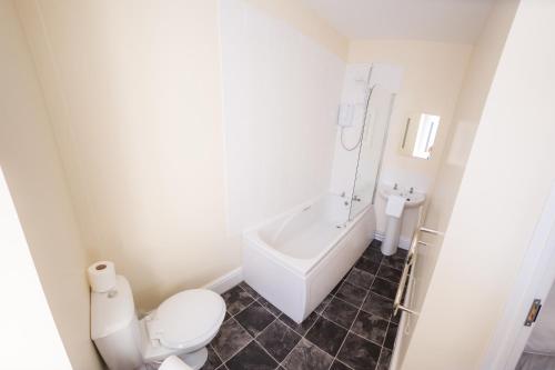 ein Badezimmer mit einer Badewanne, einem WC und einem Waschbecken in der Unterkunft Queensbridge Hotel in Aberystwyth