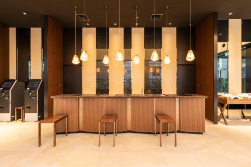 a lobby with a counter with stools and a bar at Tokyu Stay Hakata in Fukuoka