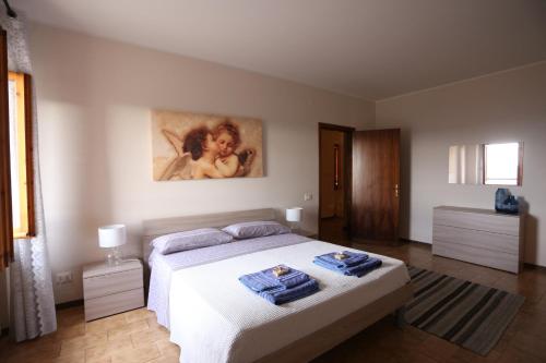 Un dormitorio con una cama y un cuadro en la pared. en La Dimora sul colle, en Potenza Picena