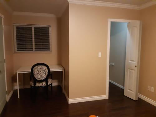 a dining room with a chair and a desk at Vancouver Jenny's Guesthouse in Coquitlam