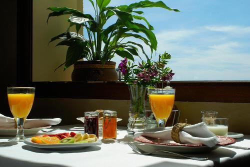 a table with a plate of food and glasses of orange juice at Cases Noves - Boutique Accommodation - Adults Only in Guadalest