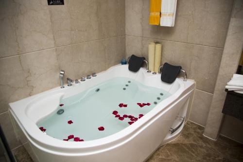 a bath tub with hearts painted on it in a bathroom at Gladden Hotel Jiangmen in Jiangmen