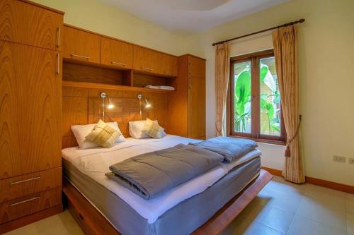 a large bed in a bedroom with a window at Khao Tao lake & beach villas, Hua Hin. in Khao Tao