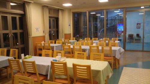a dining room with tables and chairs and tablesktop at Fujibou Hotel in Fujikawaguchiko