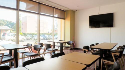 a classroom with tables and chairs and a large window at 金門微醺民宿 Kinmen TipsyHotel B&B in Jincheng