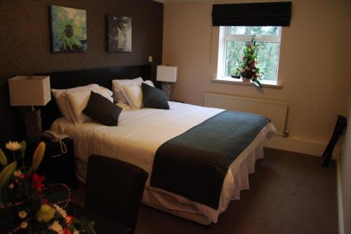 a bedroom with a large bed and a window at Greenvale Hotel in Cookstown