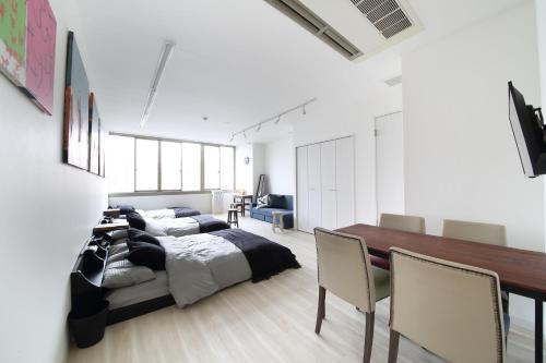 1 dormitorio con 1 cama, mesa y sillas en Culinary Bed&Art 402, en Hamamatsu