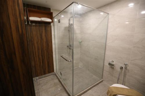 una doccia con porta in vetro in bagno di AMERALD RESORT HOTEL DESARU a Pengerang