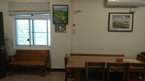 a dining room with a table and a window at Ho Hai Yan Homestay in Chenggong