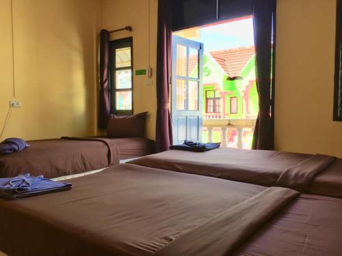 2 camas en una habitación con ventana en Andaman Place Guesthouse, en Patong Beach
