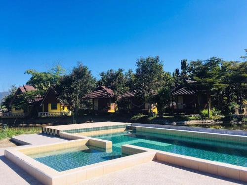 a swimming pool in front of a house at JJ&J Garden in Pai