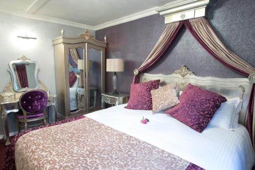 a bedroom with a large bed with purple walls at Greenvale Hotel in Cookstown