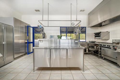 a large commercial kitchen with stainless steel appliances at Doyles on the Bay in Kingscote