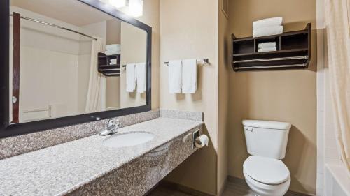 uma casa de banho com um lavatório, um WC e um espelho. em Best Western Plus Cutting Horse Inn & Suites em Weatherford