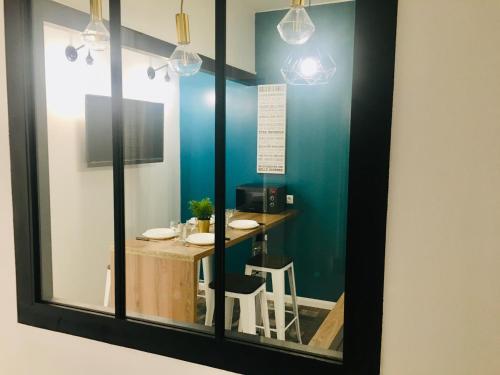 un miroir reflétant une table dans une pièce dans l'établissement MAGNIFIQUE T2 NEUF TOP EMPLACEMENT !, à Sète