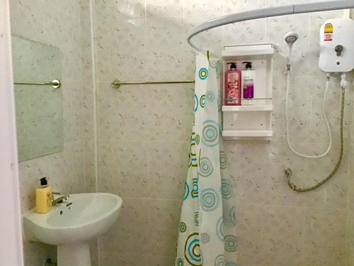 a bathroom with a shower curtain and a sink at Daddy's homestay in Ban Bang Krasan