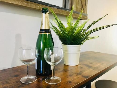 une bouteille de vin et deux verres sur une table dans l'établissement MAGNIFIQUE T2 NEUF TOP EMPLACEMENT !, à Sète