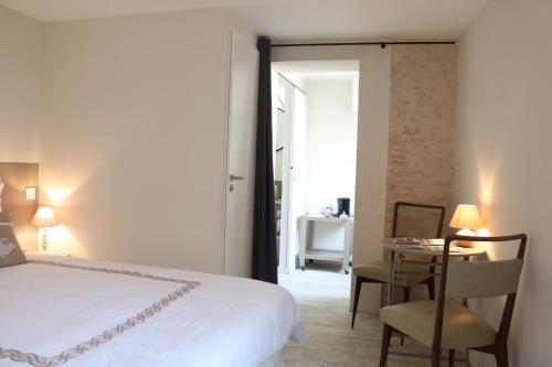 ラ・クアルド・シュル・メールにあるChambre "Chèvrefeuille"のベッドルーム1室(ベッド1台、テーブル、椅子付)
