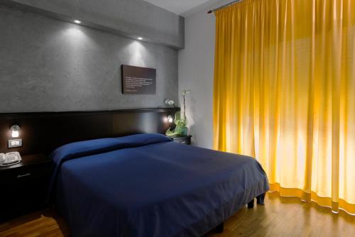 a bedroom with a blue bed and a yellow curtain at Residence Annunziata in Messina