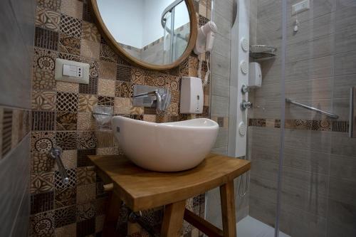 een badkamer met een witte wastafel en een spiegel bij Agorà Mura Greche B&b in Napels