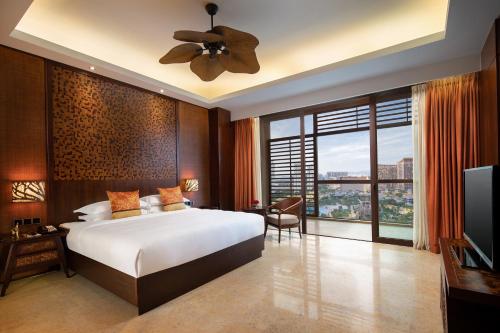 a bedroom with a bed and a large window at Mangrove Tree Resort World Sanya Bay-Kapok in Sanya