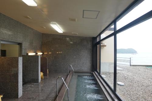 a room with a pool of water in a building at Hotel Nami in Kumano