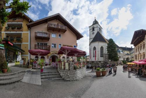 a town square with a building and a church at Hotel Weisser Bär in St. Wolfgang