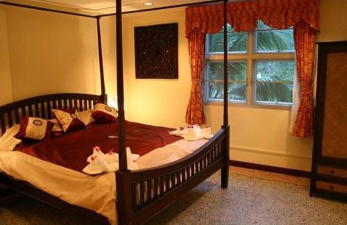 Un dormitorio con una cama con dosel y dos toallas encima. en Tolmaj Family Apartment, en Ao Nang Beach