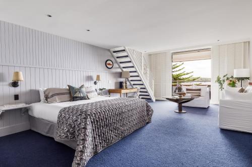 a bedroom with a large bed and a staircase at Watsons Bay Boutique Hotel in Sydney