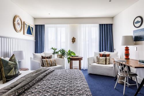 a hotel room with a bed and a desk and chairs at Watsons Bay Boutique Hotel in Sydney