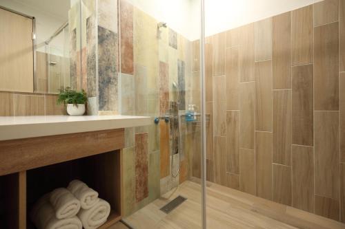 a bathroom with a shower with a sink and a glass shower door at Hai Sheng Wei B&B in Dahan