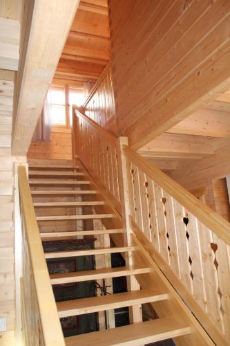 a staircase in a log cabin with wooden ceilings at Schlosswirt Chalets & Apartments in Großkirchheim