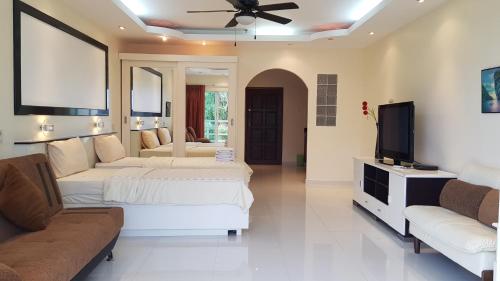 a living room with two beds and a flat screen tv at View Talay 6 Pattaya Beach by CANDO in Pattaya