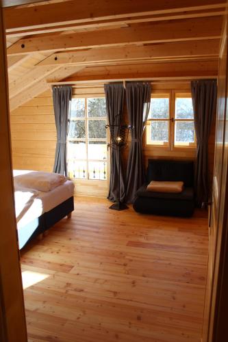 a bedroom with a bed and a couch in a room at Schlosswirt Chalets & Apartments in Großkirchheim
