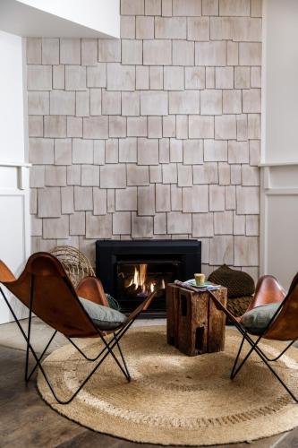 a living room with two chairs and a fireplace at Watsons Bay Boutique Hotel in Sydney