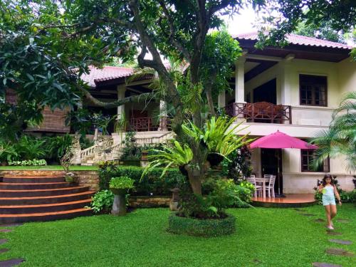a woman walking in front of a house at Jungle Garden Villa in Mayong