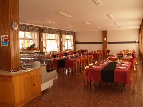 un comedor con mesas y sillas con manteles rojos en Camping Playa América, en Playa América