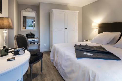 a hotel room with a bed and a desk and a bed at Résidences Alticimes in Brides-les-Bains