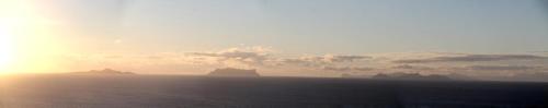 a sunset over the ocean with rocks in the water at FARINHA DE PAU - ECO B&B in Tarrafal