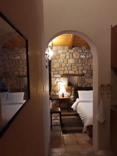 een slaapkamer met een bed in een stenen muur bij Niriides in Galaxidhion