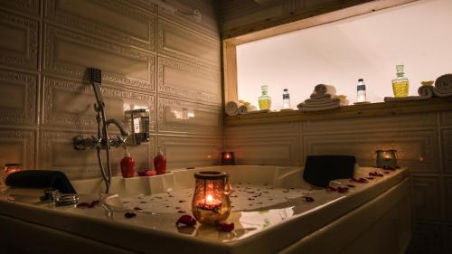 La salle de bains est pourvue d'une baignoire avec bougie. dans l'établissement D'Polo Club & Spa Resort, à Dharamshala