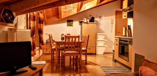 a kitchen with a table and chairs and a refrigerator at Ferienhaus Gundi in Pettneu am Arlberg