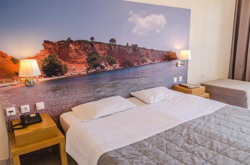 a bedroom with a bed with a painting of a river at Hotel Nereides in Patitiri
