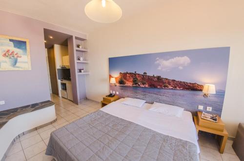 a bedroom with a bed with a painting on the wall at Hotel Nereides in Patitiri